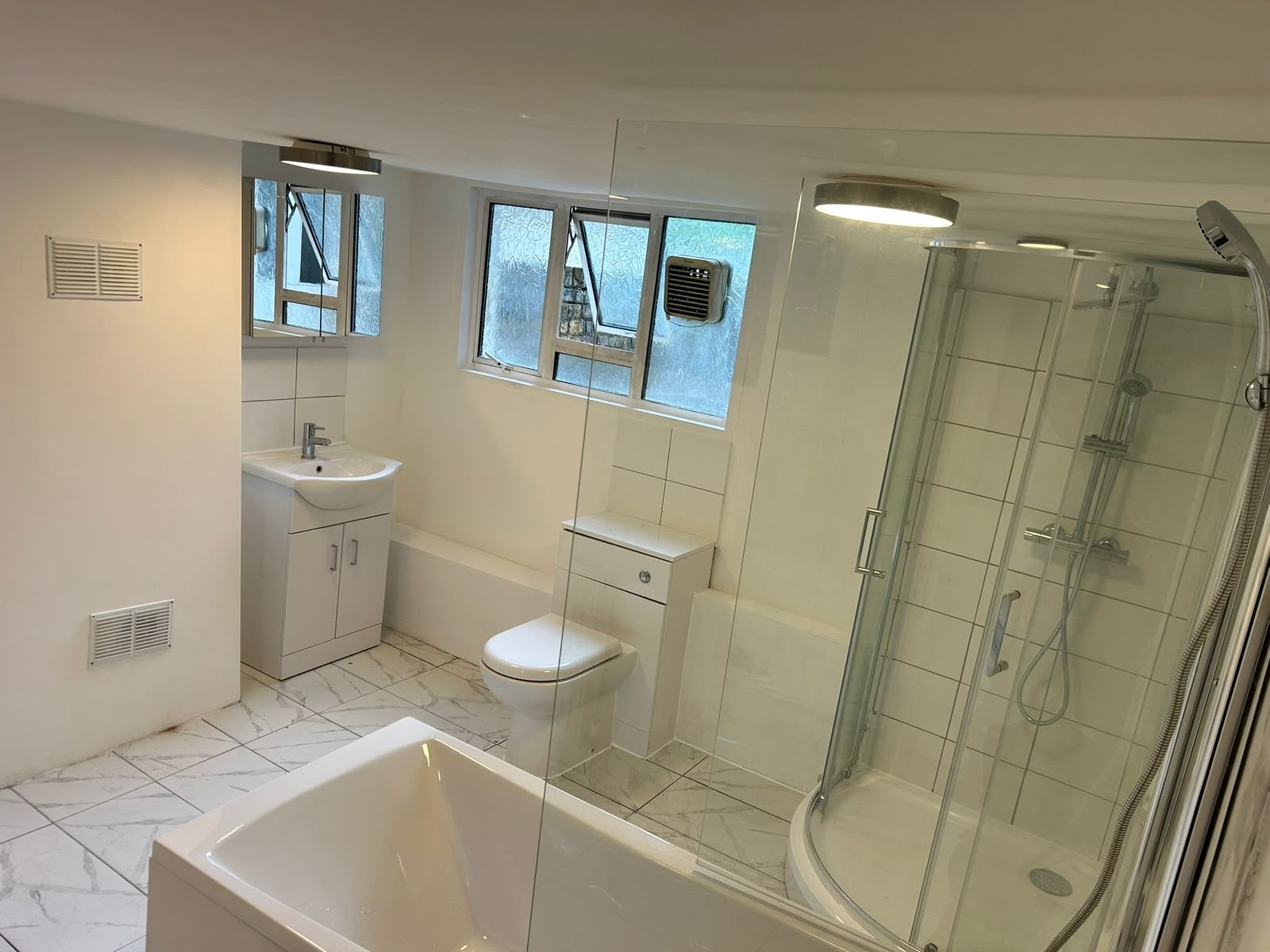 Bathroom renovation with corner shower and marble tile