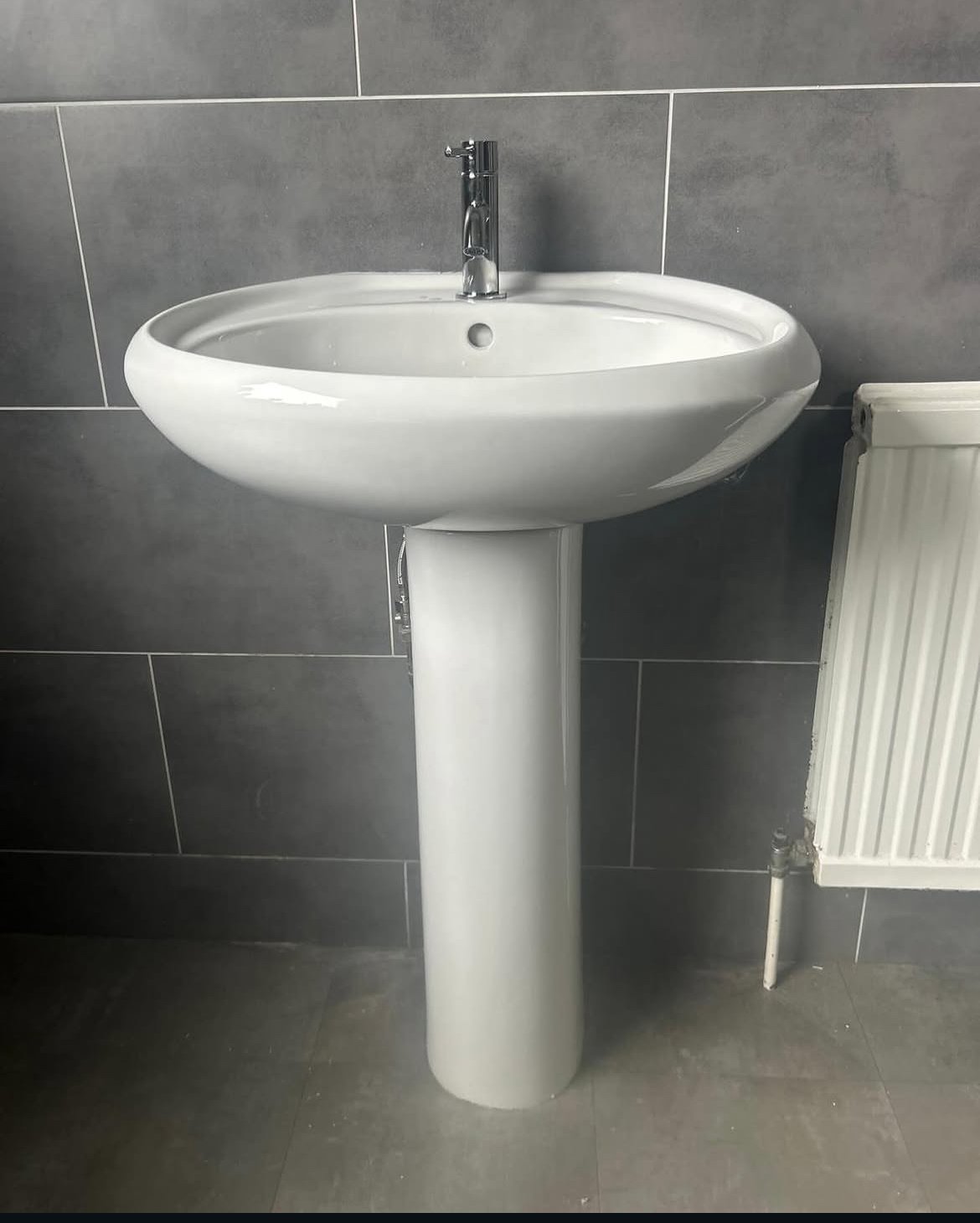 Pedestal sink and radiator installation