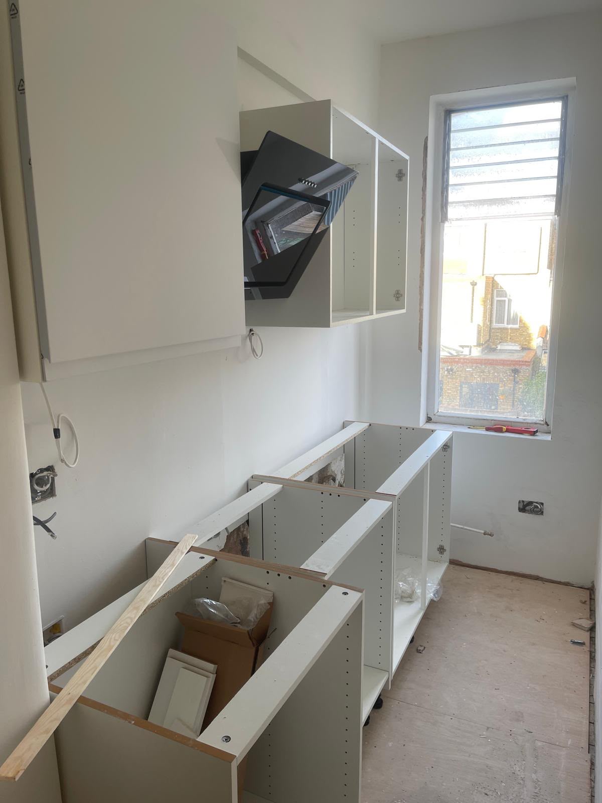 Galley kitchen before fit-out, bare carcasses and extractor hanging